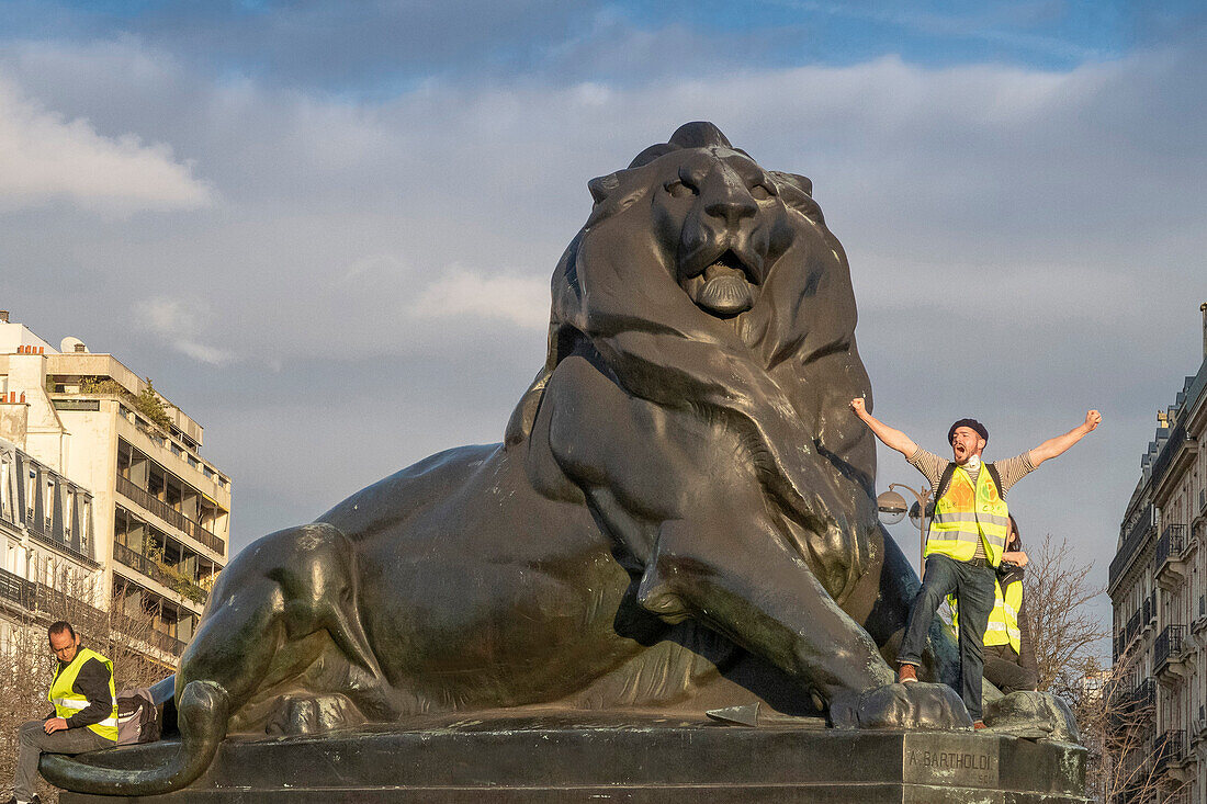 March 2,2019. Paris. Demonstration of the Yellow Vests against the policy of the Macron government. Act 16. Place Denfert-Rochereau. A Yellow Vest and "The Lion of Belfort",statue of Auguste Bartholdi (1880).