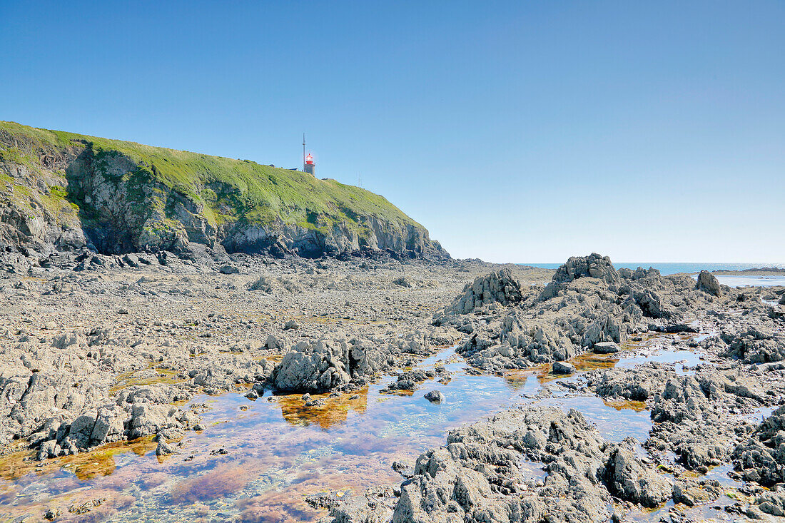 France. Normandy. Department of Manche. Granville during the summer. View of the coast and the lighthouse at ebb tide.