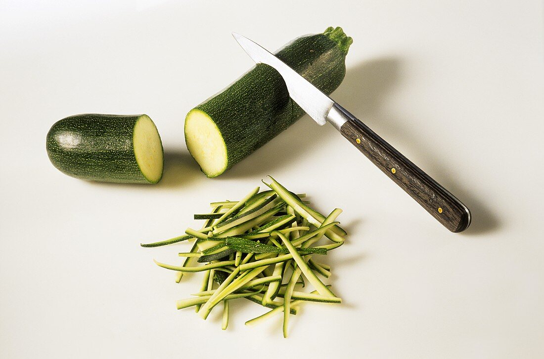 Angeschnittene Zucchini mit Messer & Zucchinijulienne