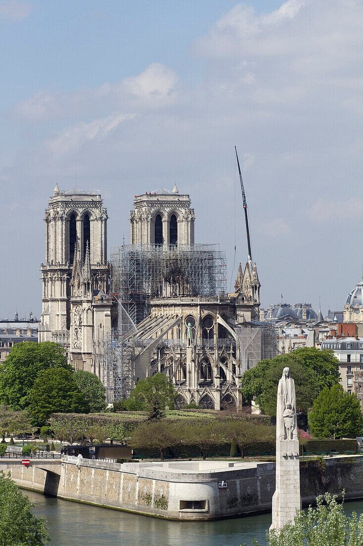 France,Paris,75,1st arrondissement,Ile de la Cite,Cathedral Notre-Dame,after the fire,in the foreground the statue of Saint-Genevieve,Holy Patroness of Paris,at the Pont de la Tournelle,April,17th 2019