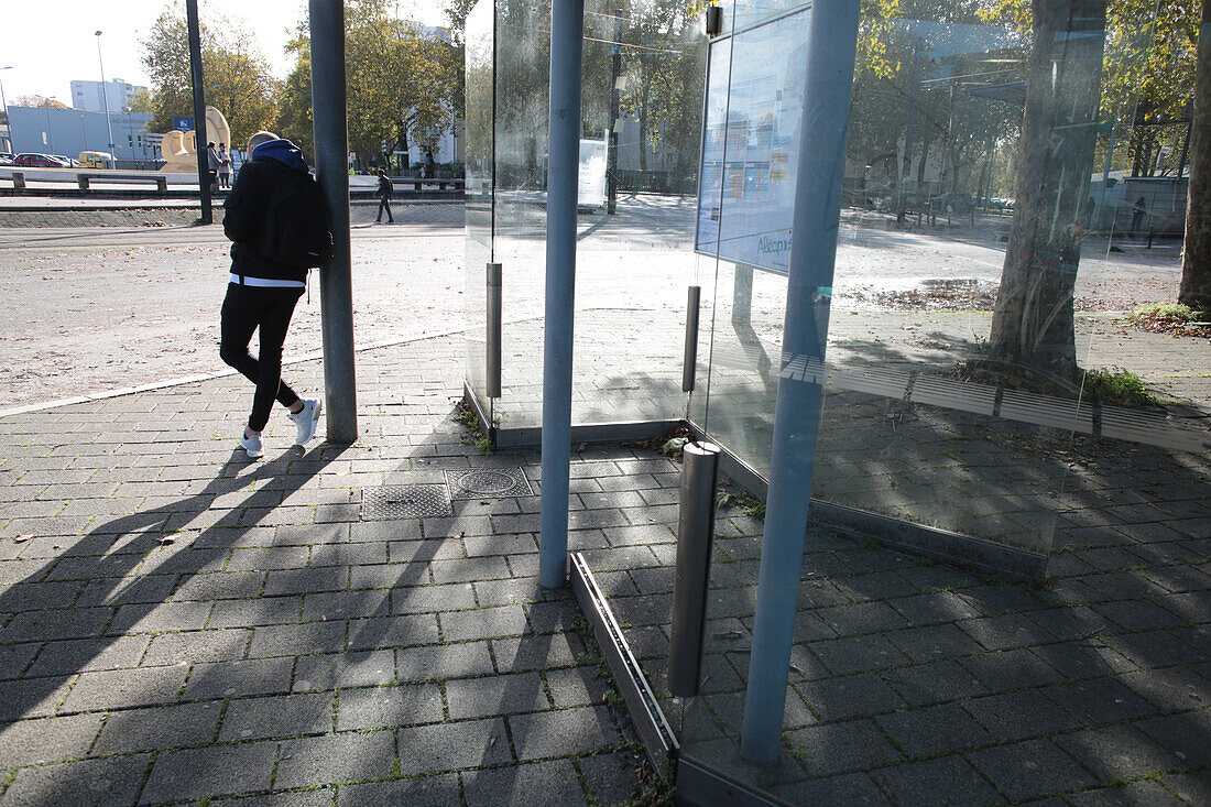 France,Nantes,44,Pirmil district,young man waiting for the bus at a stop.