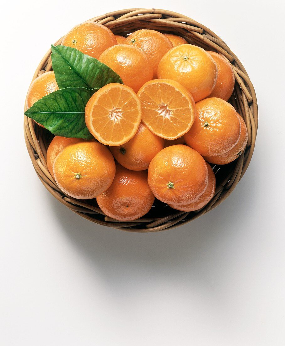 Mandarinen (Satsuma) in einer Korbschale, eine halbiert