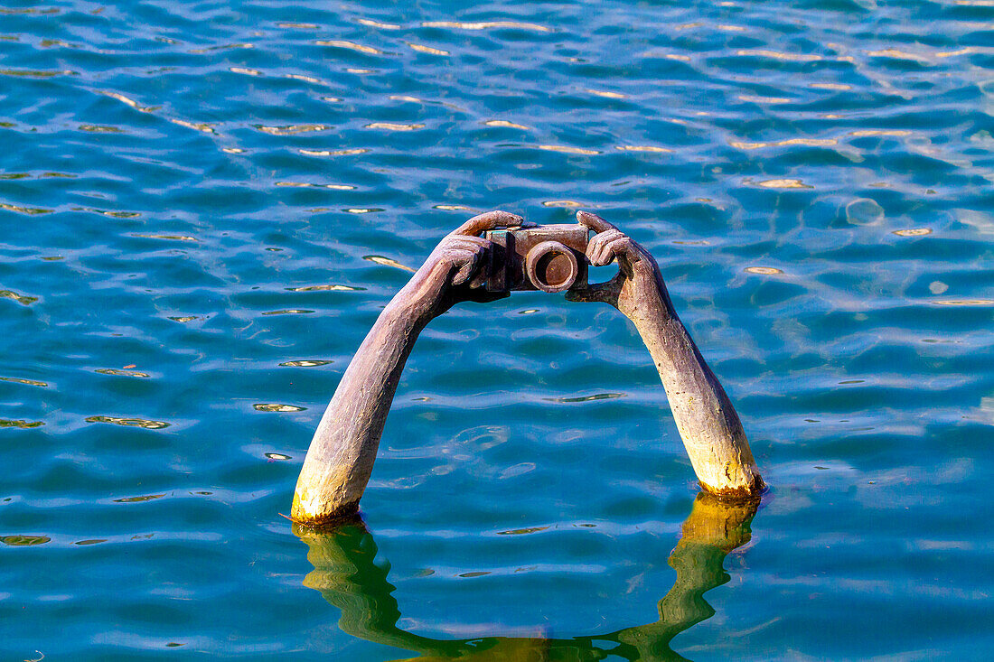 France,Troyes,submerged statue of arms holding a camera