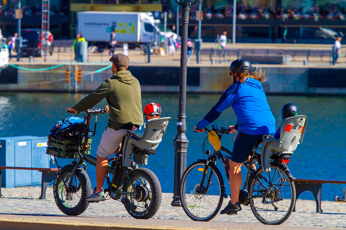 Europa,Skandinavien,Schweden. Stockholm. Zwei Väter und Kind auf dem Fahrrad