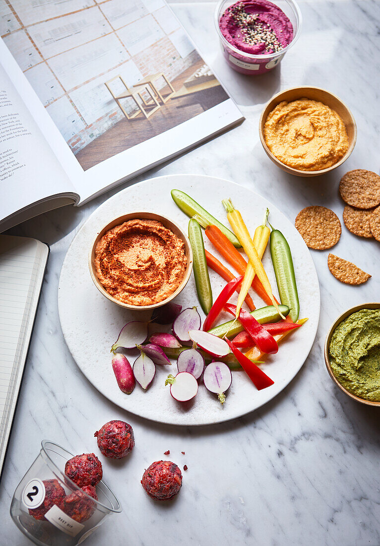 Various hummus dips, vegetables and crackers