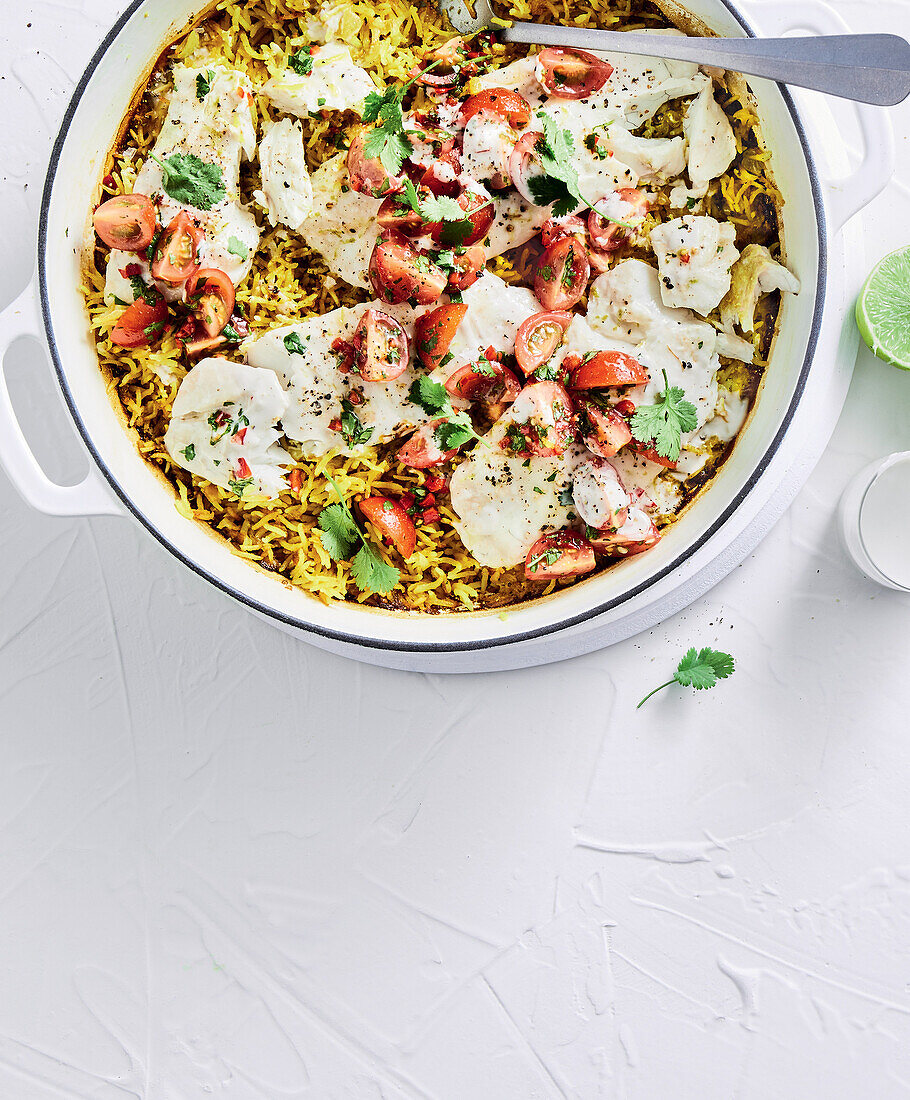 Coconut fish with turmeric rice in a pan