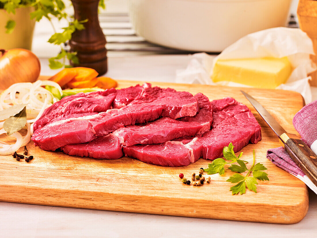 Raw beef steaks on a wooden board