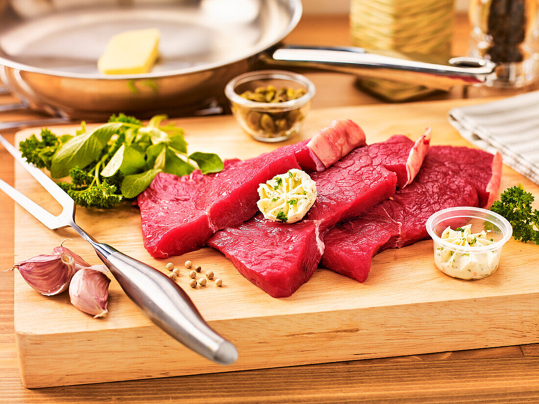 Raw beef steaks with herb butter and spices