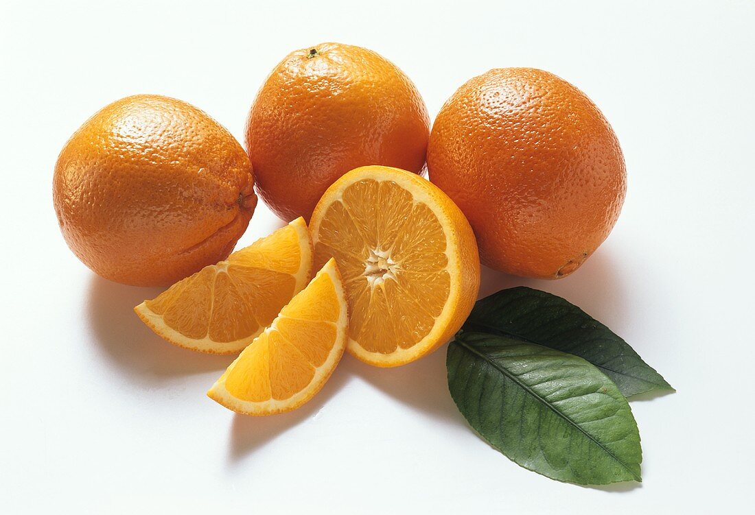 Drei Orangen, Orangenhälfte, -schnitze & zwei Blätter