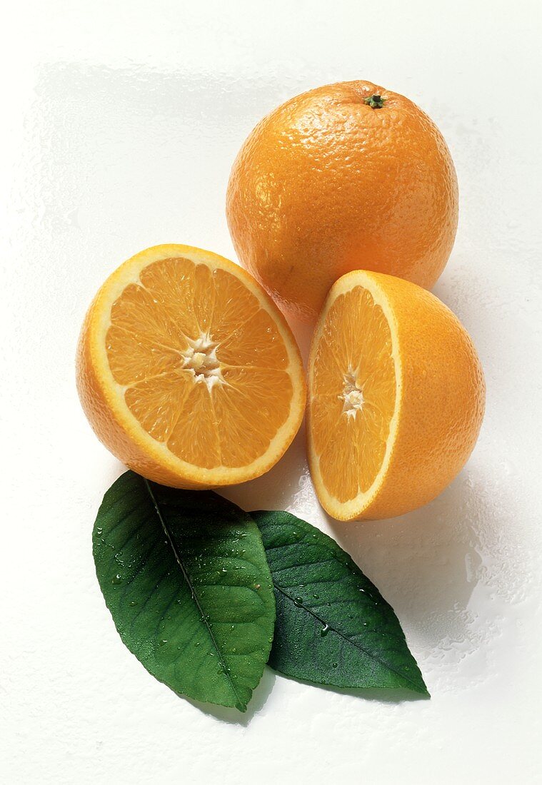 A Whole and Halved Orange with Leaves