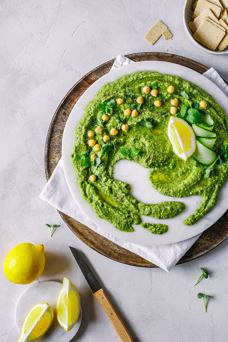 Herb hummus with lemon wedges and crackers