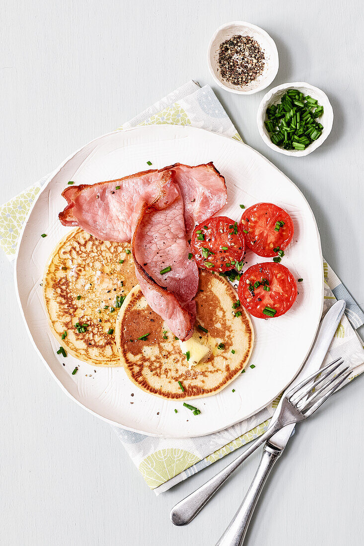 Potato pancakes with tomatoes and crispy bacon