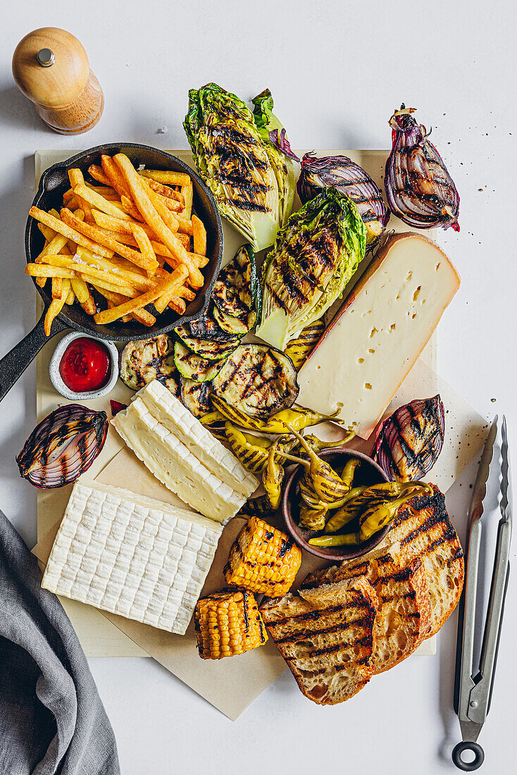 Grillgemüse und Käsesorten mit Pommes und Brot