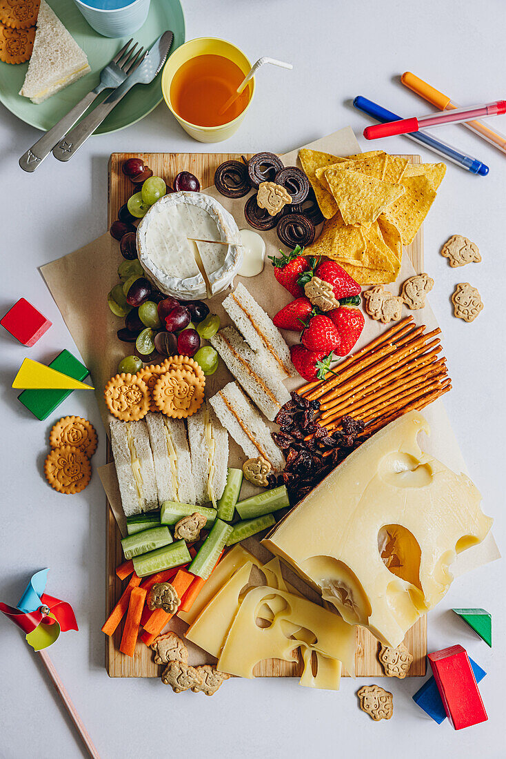 Käseplatte mit Gemüse, Crackern und Fruchtsnacks