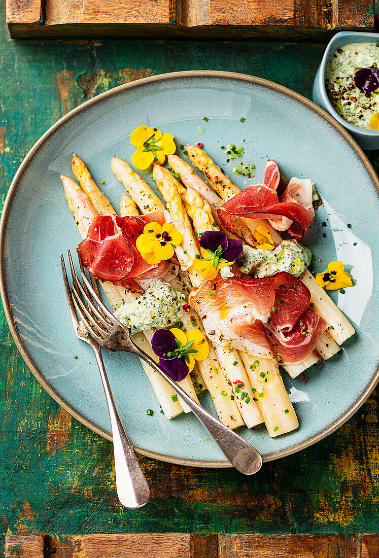 Asparagus from the tray with ham and green sauce