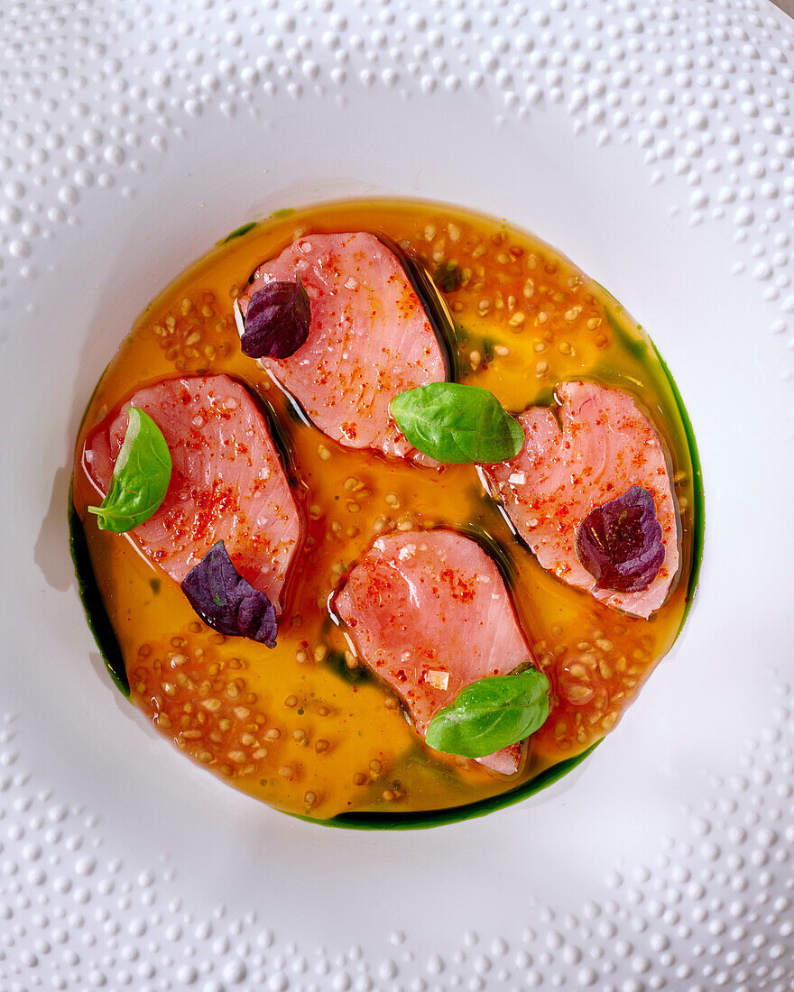 Bonito sashimi in tomato consommé with basil oil