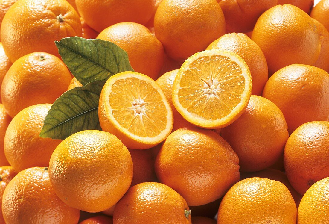 Viele Orangen, eine halbierte obenauf (Ausschnitt)