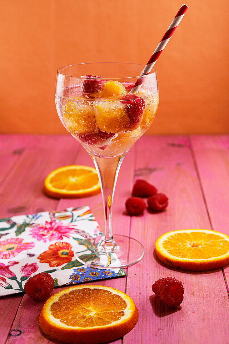 Water with raspberry and orange ice cubes