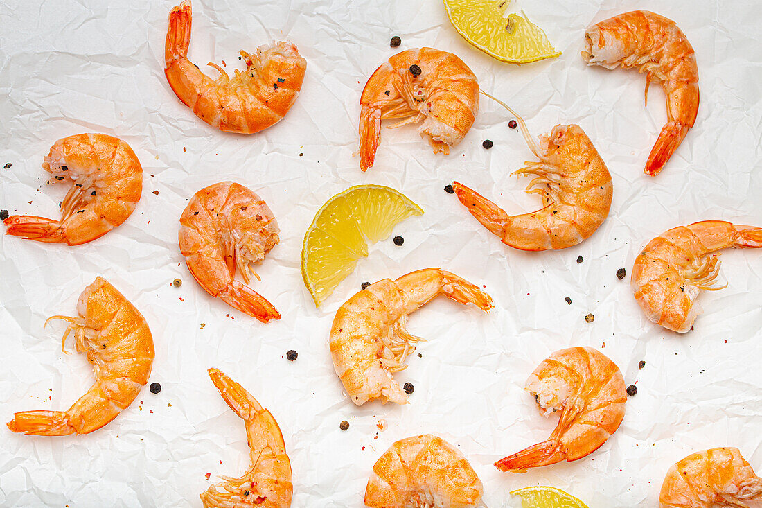 Cooked prawns with lemon wedges and pepper