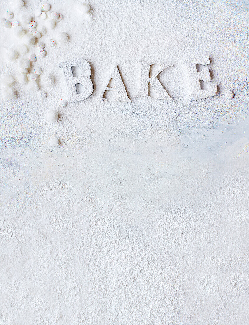 'BAKE' lettering dusted with icing sugar