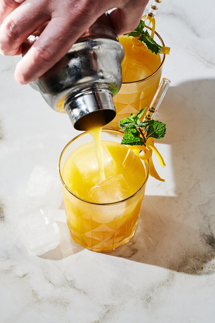 Passion fruit and tequila cocktail with lemon zest and mint