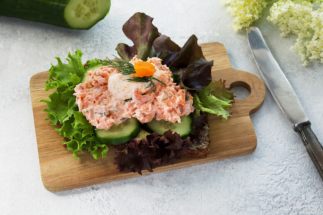 Scandinavian smørrebrød with salmon salad and masago caviar