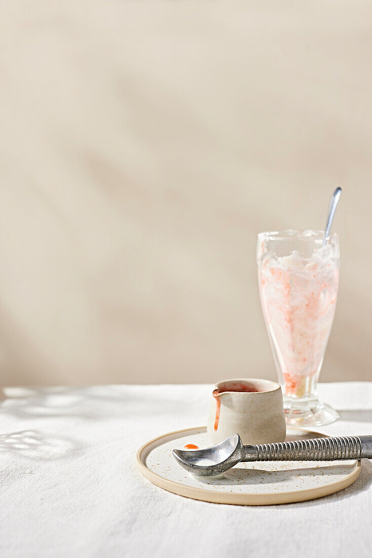 Empty glass with leftover strawberry ice cream