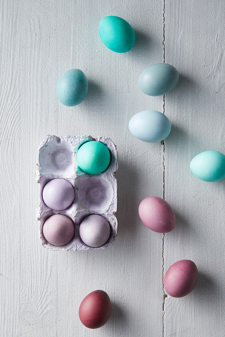 Colourful Easter eggs in egg carton and next to it