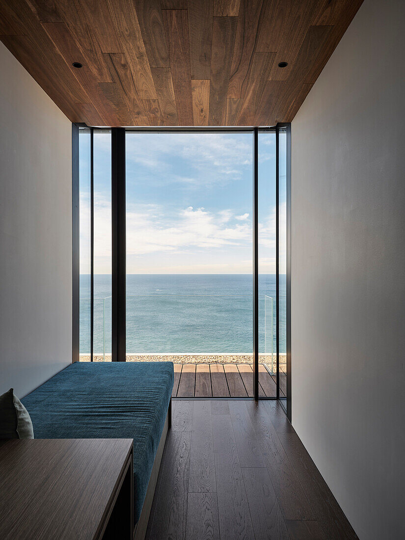 Sea view through floor-to-ceiling windows, wooden floor and ceiling