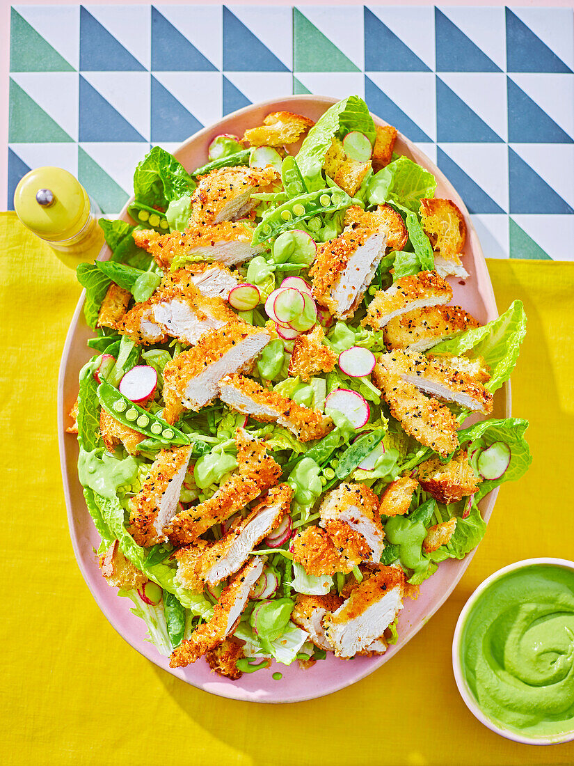 Caesar salad with chicken schnitzel and avocado dip