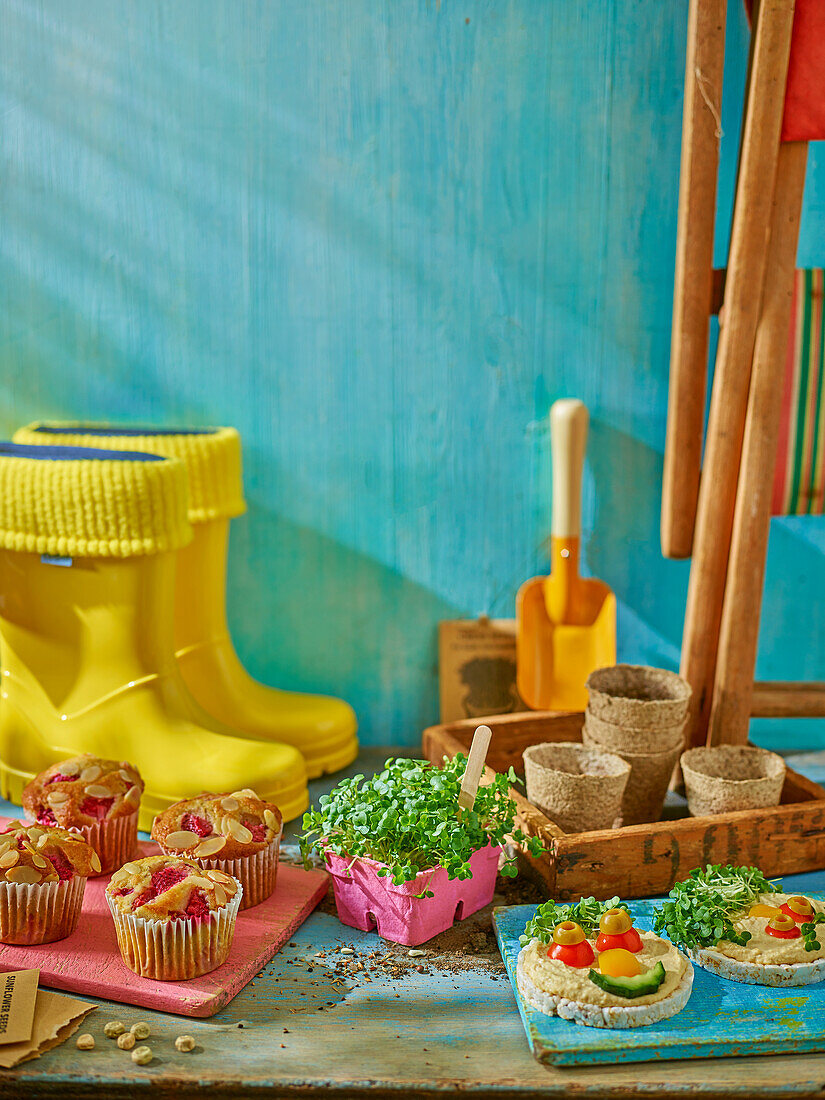 Raspberry and almond muffins and rice cake faces with cress and vegetables