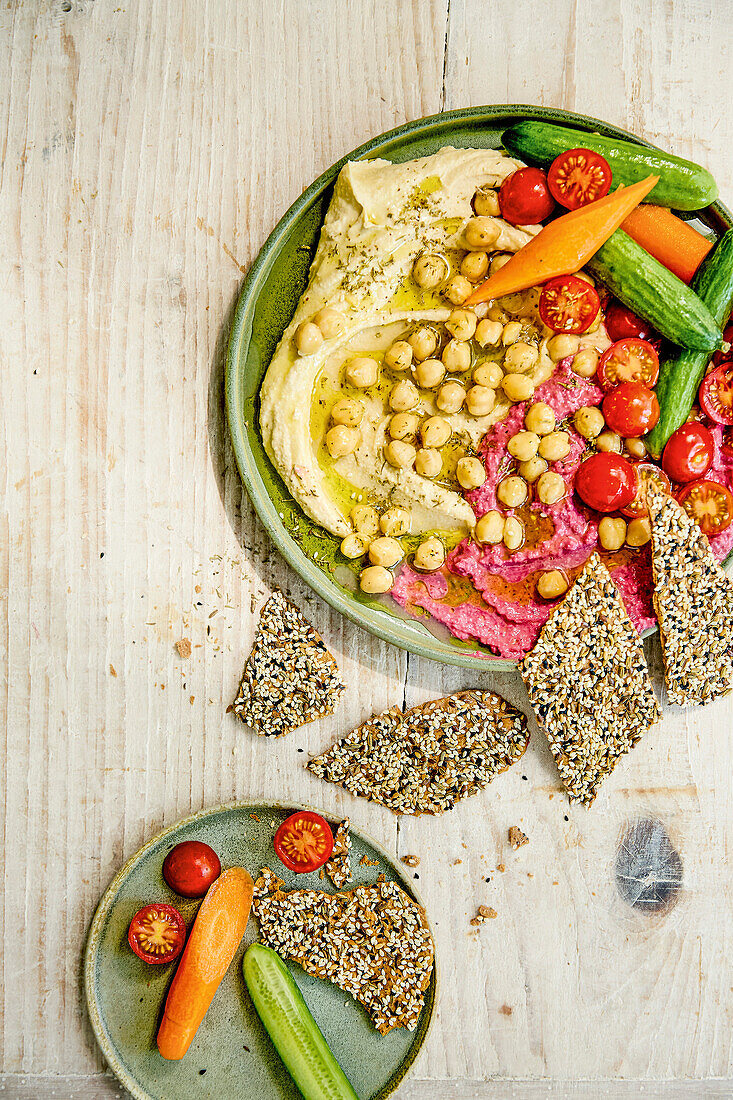 Gemüseplatte mit verschiedenen Hummus-Variationen