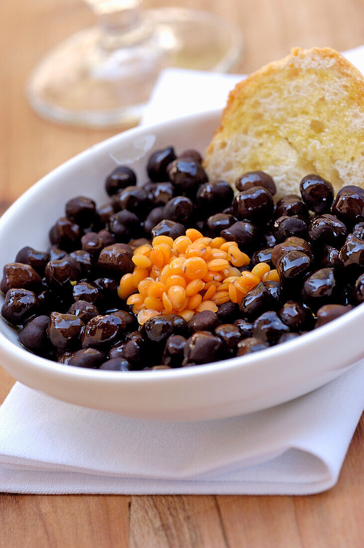 Schwarze Oliven und rote Linsen mit Brot