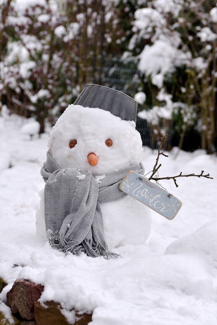 Schneemann mit grauem Schal, Topf und Winter-Holzschild