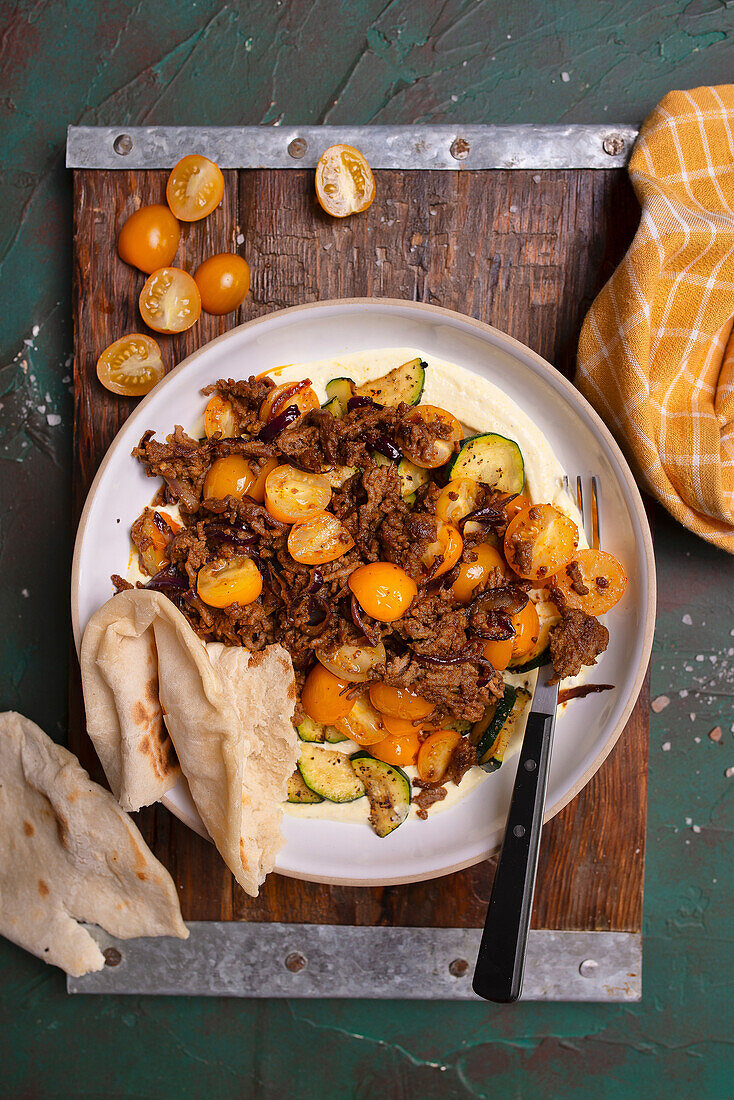 Minced beef with yellow tomatoes, courgettes and naan bread