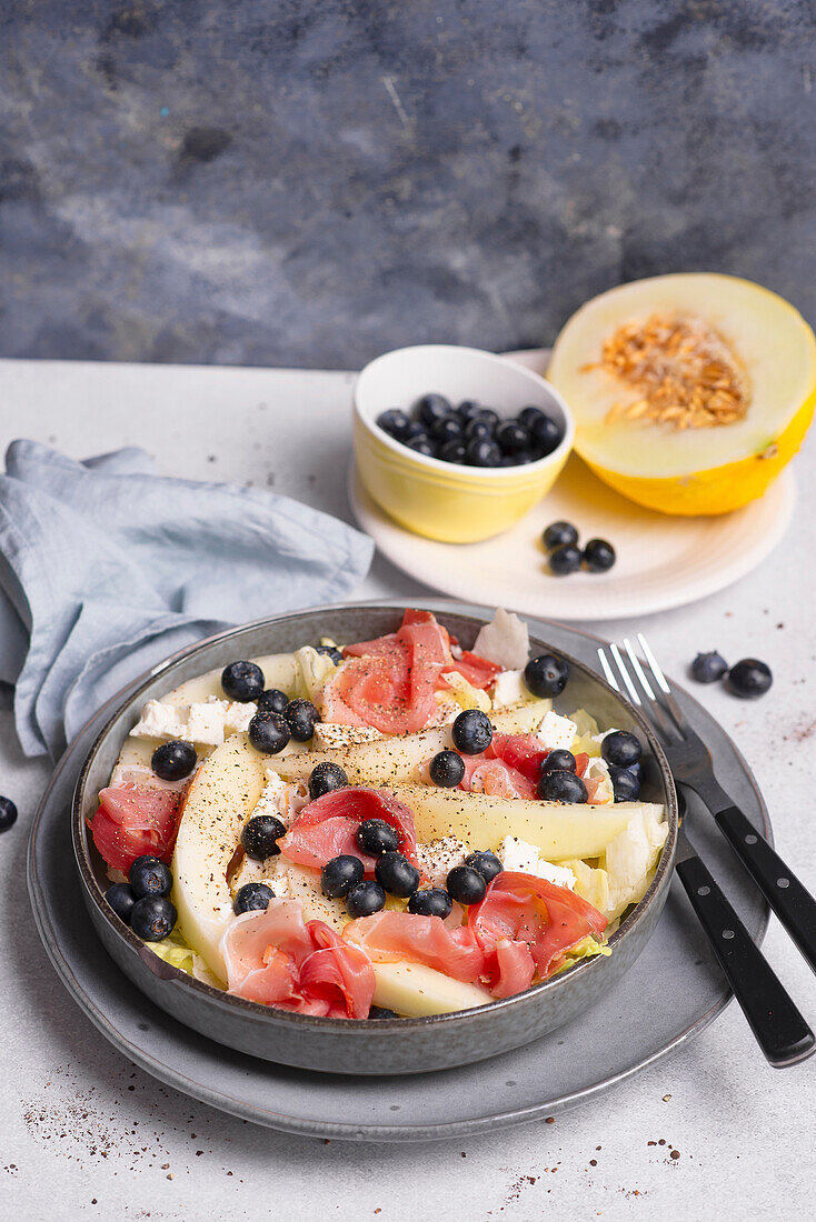 Melon salad with blueberries, feta and prosciutto