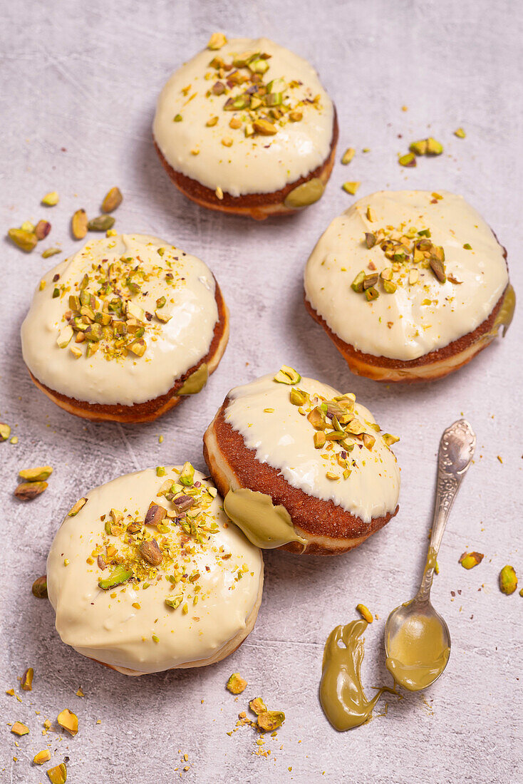 Krapfen mit Pistazienfüllung und weißer Schokoladenglasur