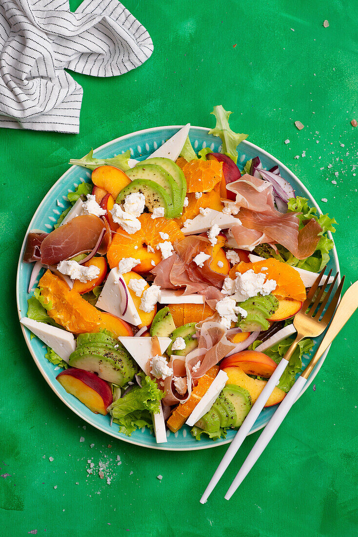 Salad with peaches, clementines, avocado, ham and cheese