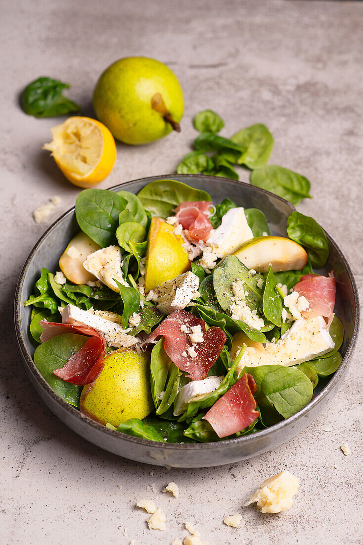 Spinatsalat mit Birne, Käse und italienischem Schinken