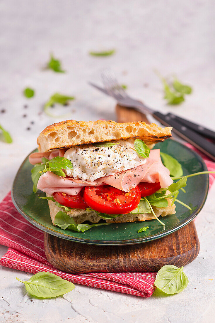 Focaccia-Sandwich mit Rucola, Tomate, Mortadella, Burrata und Basilikum