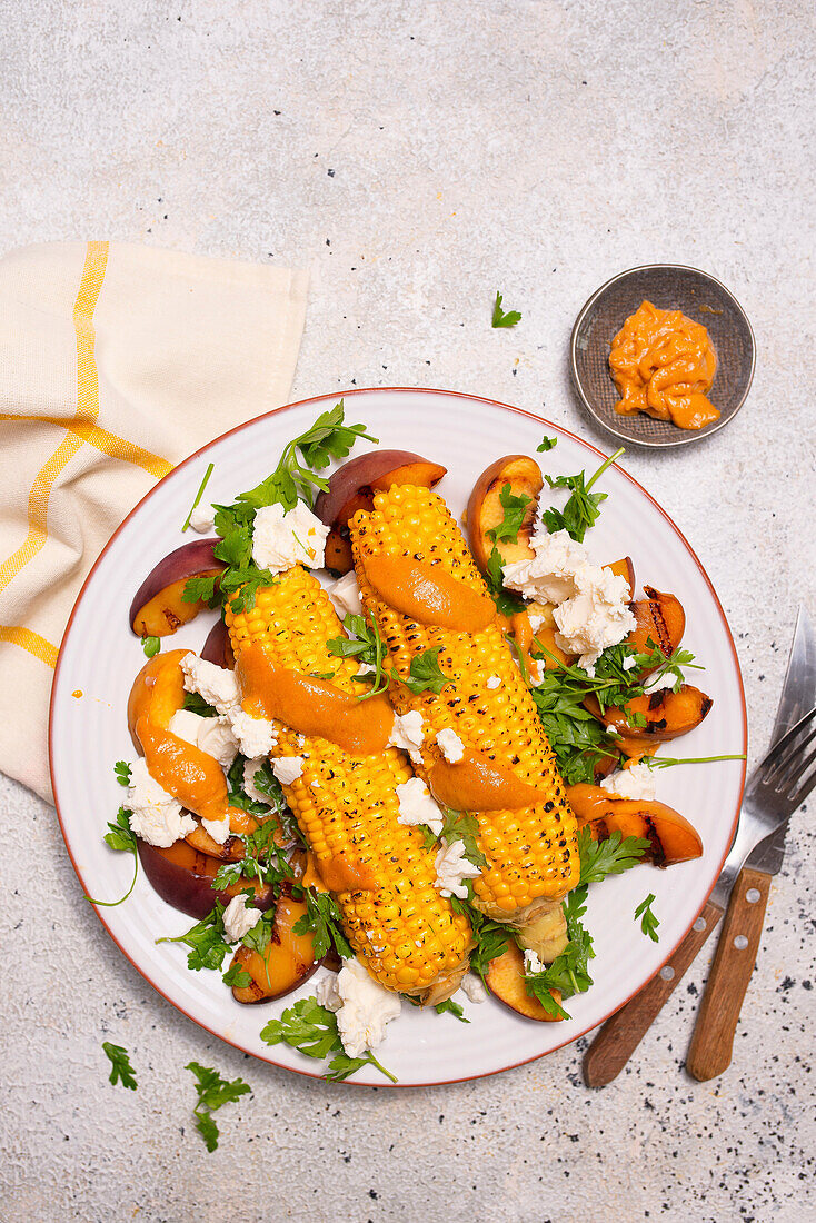 Gegrillter Mais mit Pfirsich, Satay-Sauce und Feta