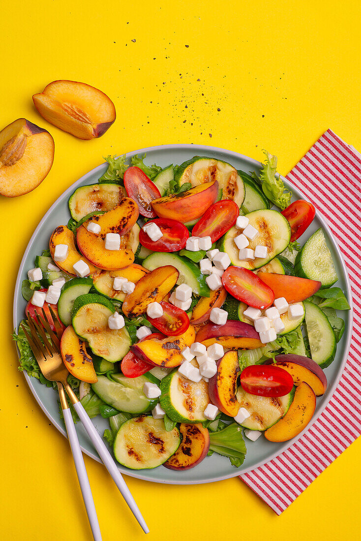 Salat mit gegrillten Zucchini, Pfirsichen, Tomaten, Gurke und Feta