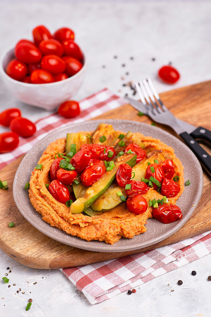 Gegrillte Zucchini und Tomaten auf Paprika-Hummus