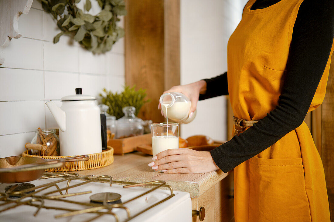 Frau gießt Milch in ein Glas