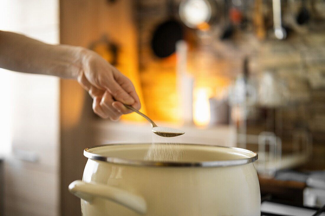 Einen Löffel Salz in Topf streuen