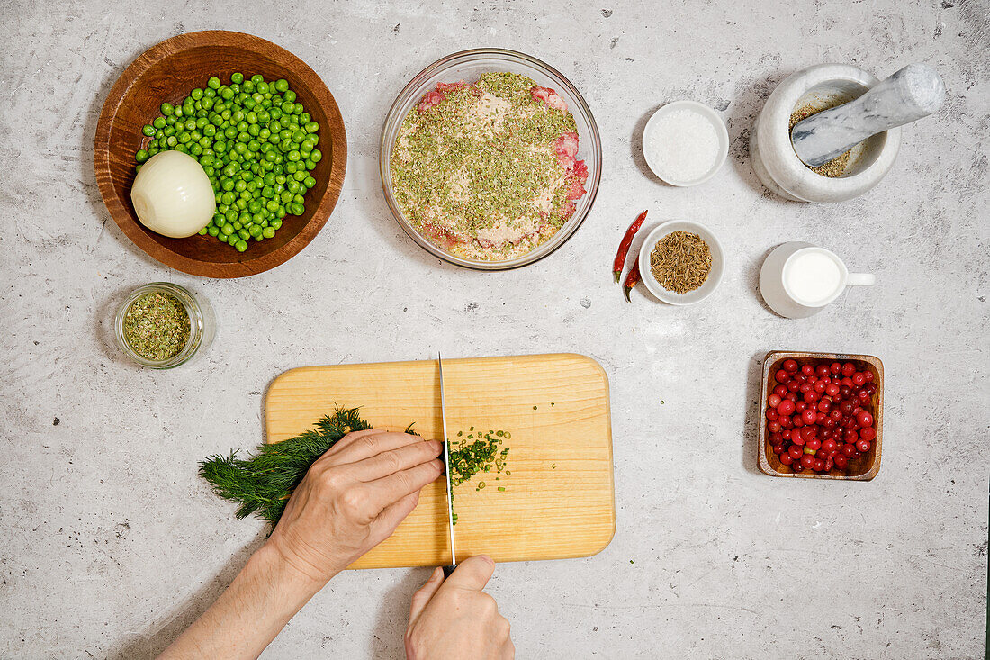 Preparing meatballs with peas and cranberry sauce