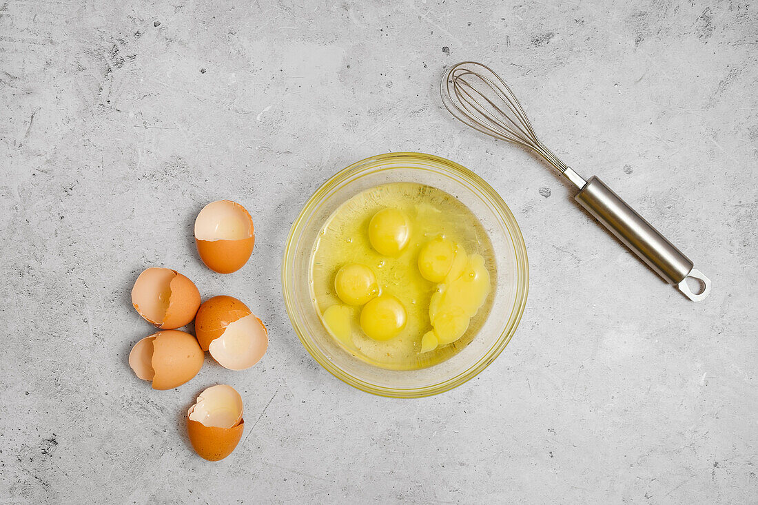 Whipped eggs with egg shells and whisk