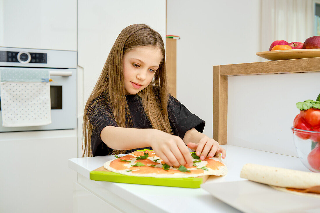 Mädchen belegt Wrap mit Lachs und Kräutern