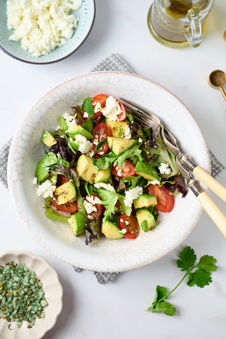 Salat mit Avocado, Tomaten, Blattsalat und Fetakäse