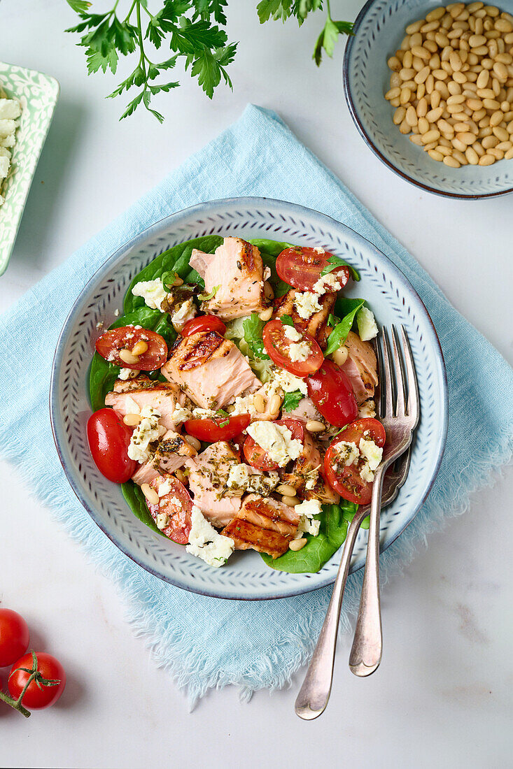 Salat mit Lachs, Tomaten, Spinat, Feta und Pinienkernen